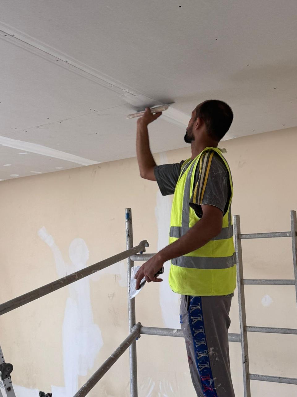 Ceiling plastering and skim coat on scaffold