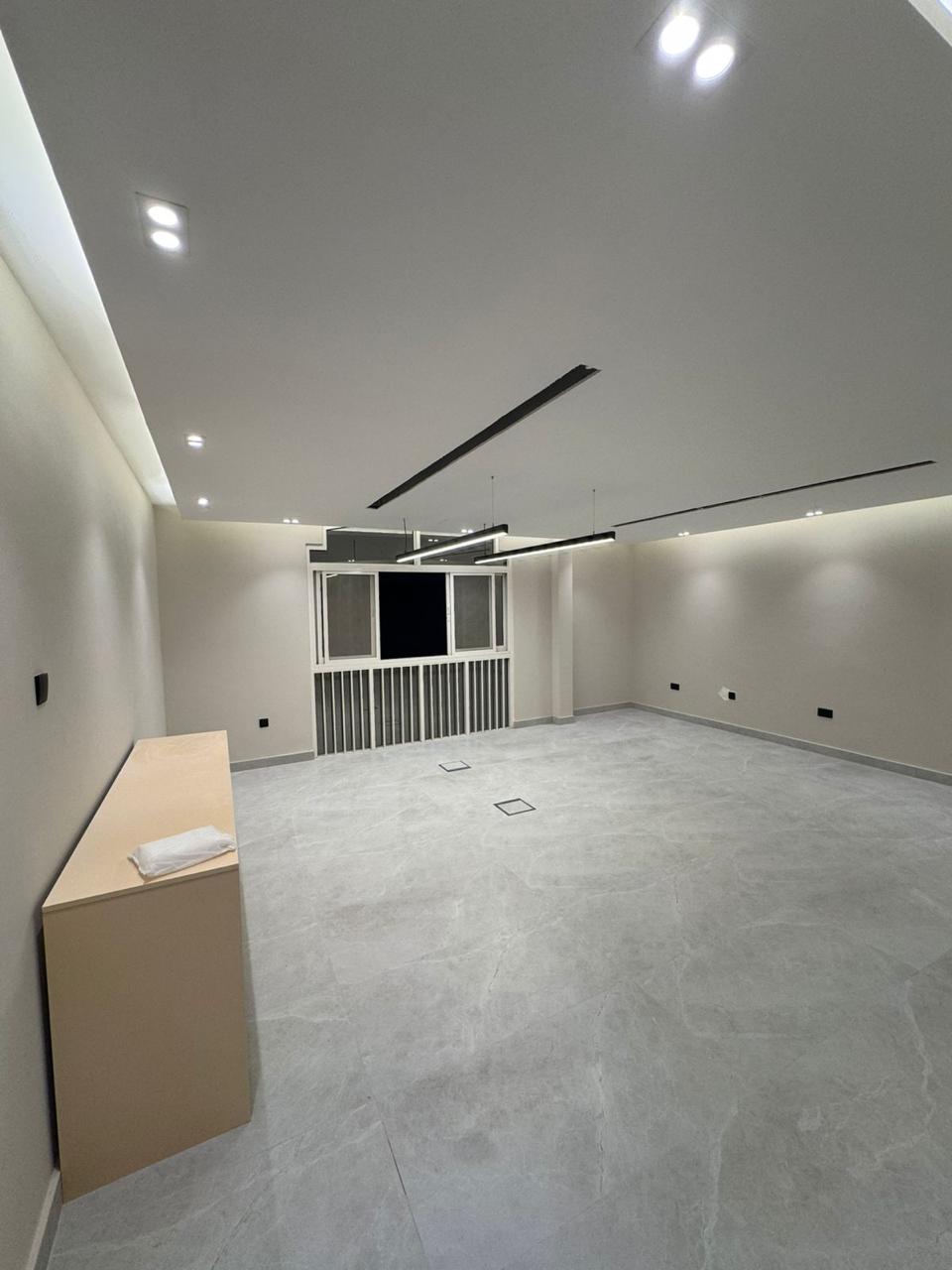 Finished room with recessed lighting and linear AC grille