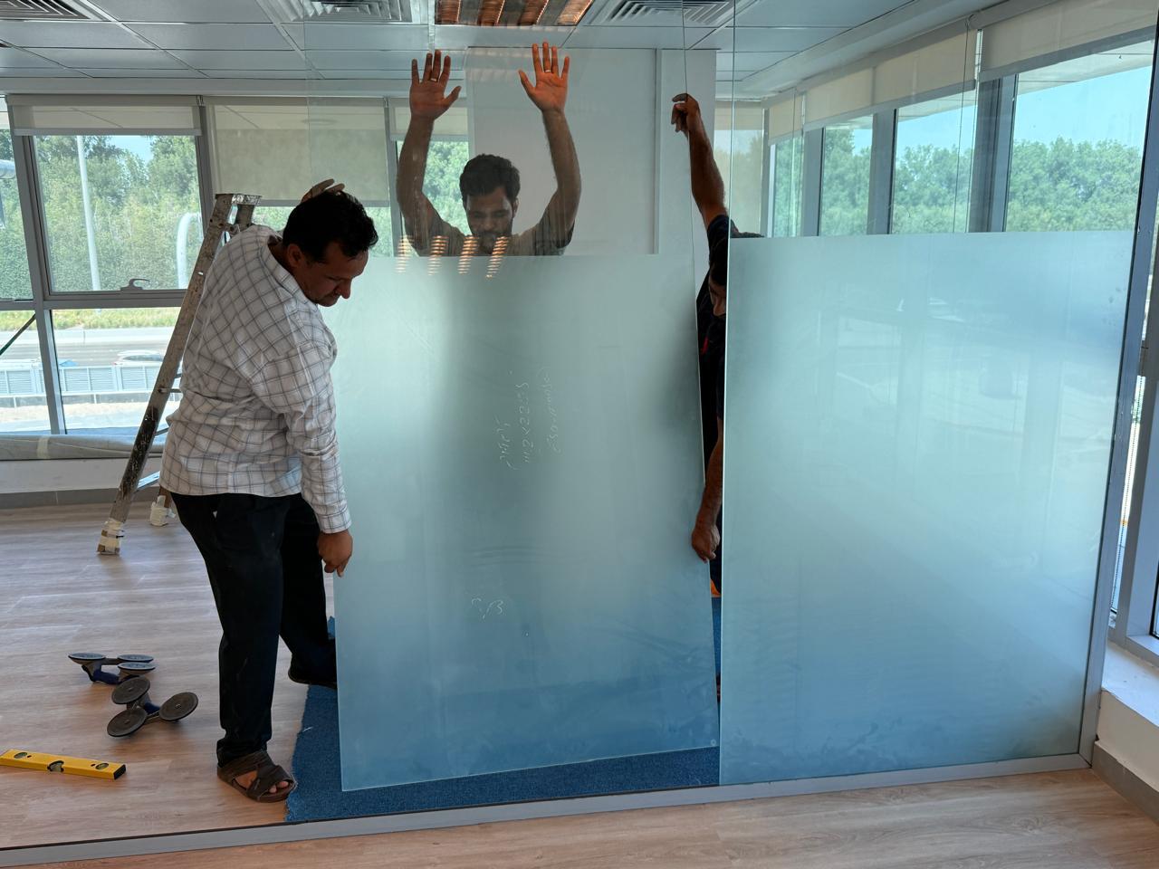 Frosted glass panel installation by two workers