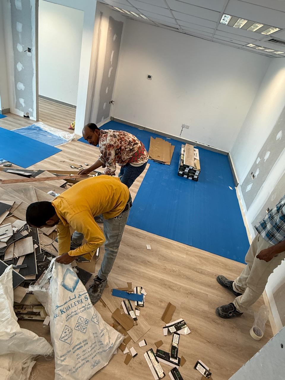 Vinyl flooring team cutting and laying planks