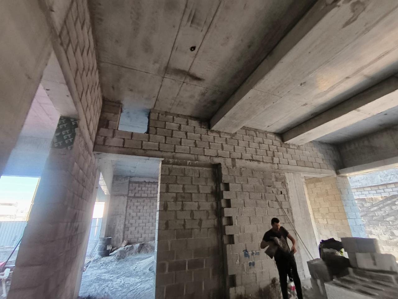 Interior blockwork construction with worker on site