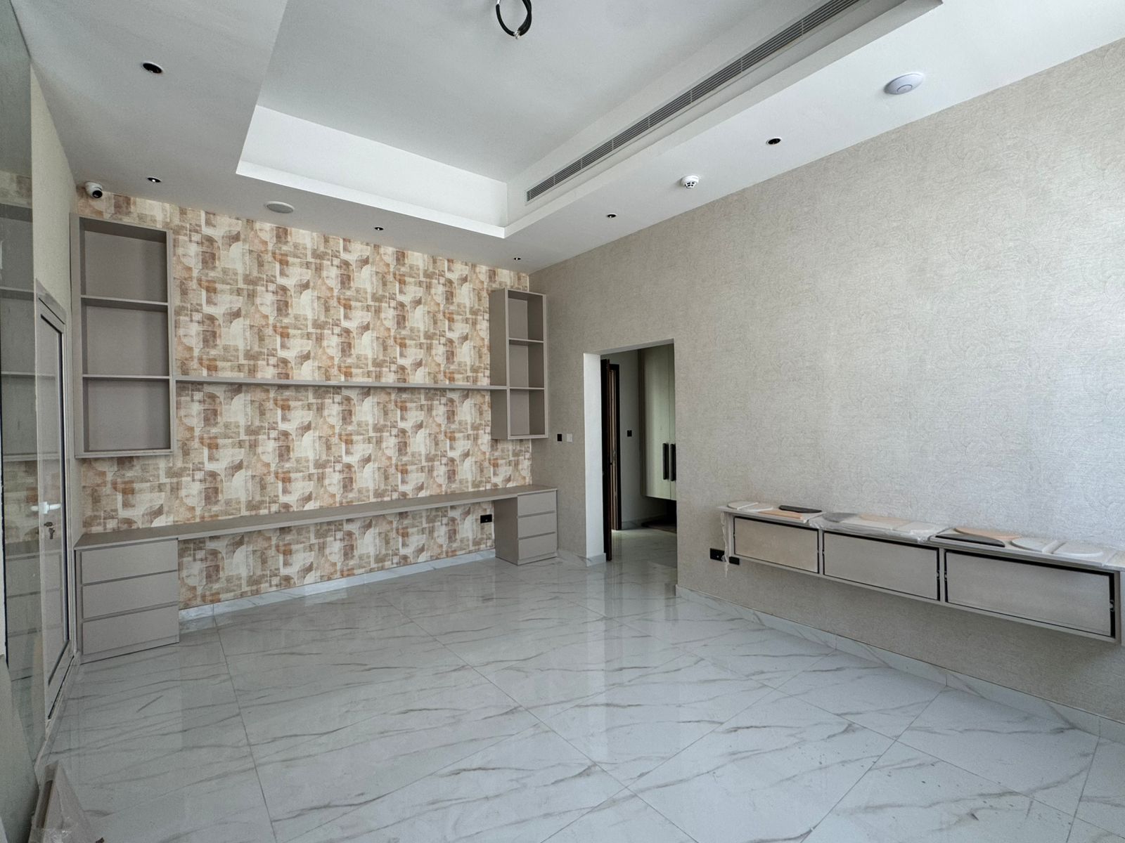 Bedroom with patterned wallpaper and built-in shelving