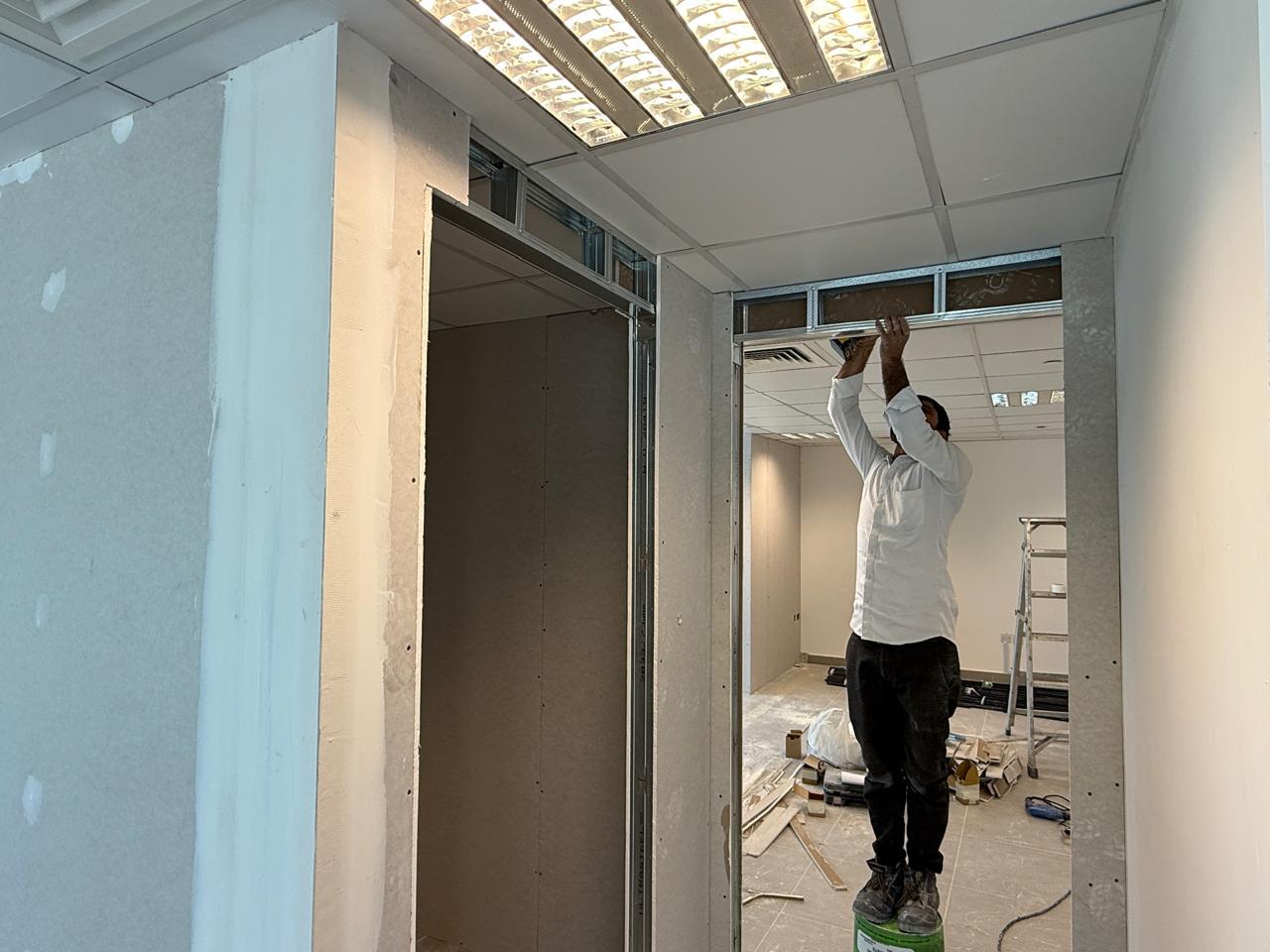 Ceiling tile installation worker in office fit-out