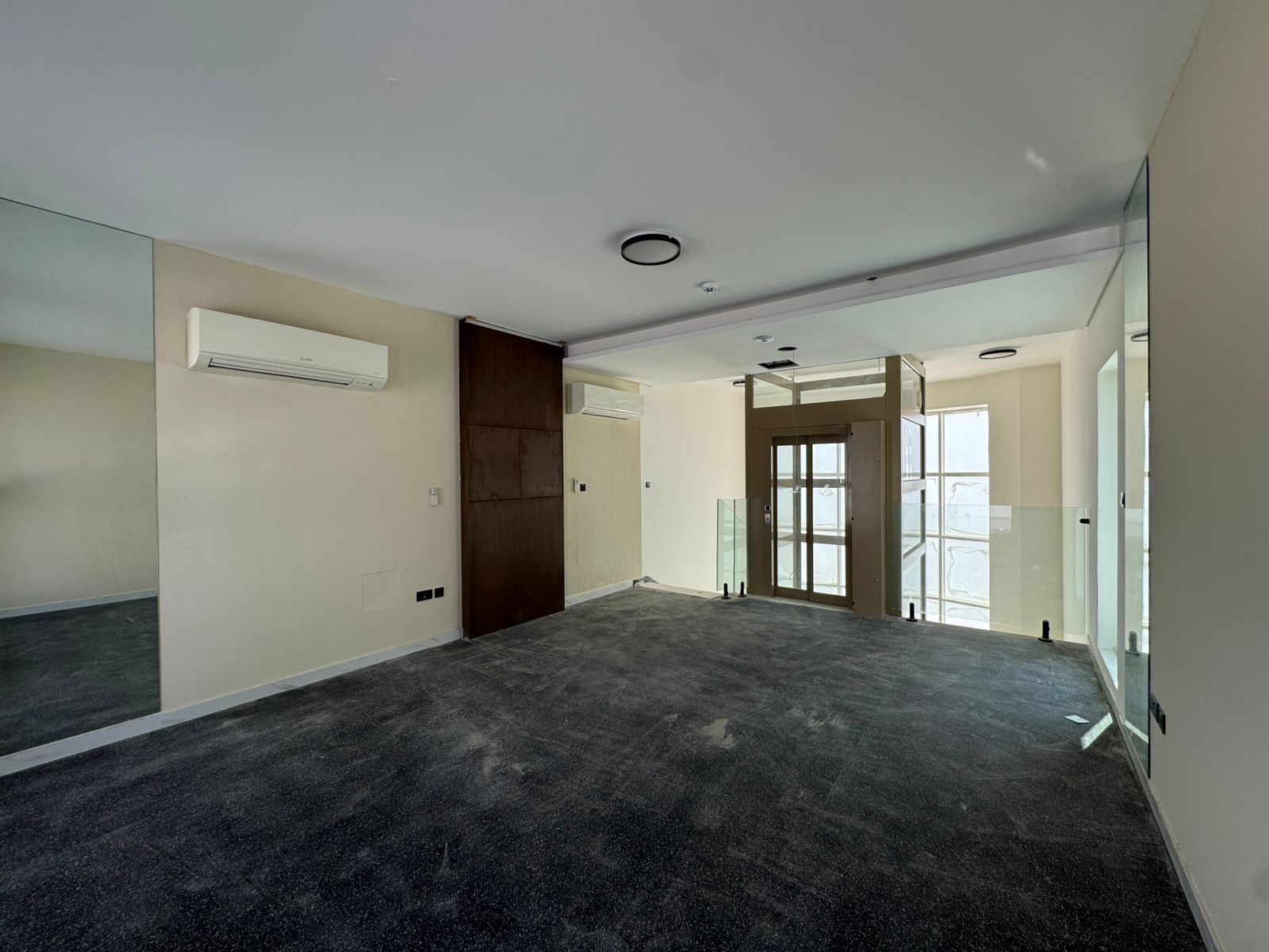Gym room with carpet flooring and glass partition