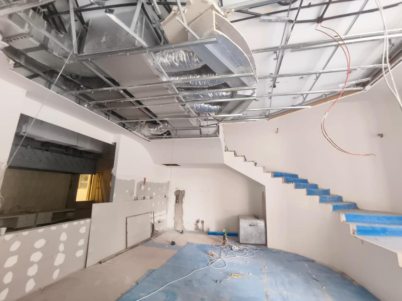 Villa staircase with MEP ductwork and drywall in progress