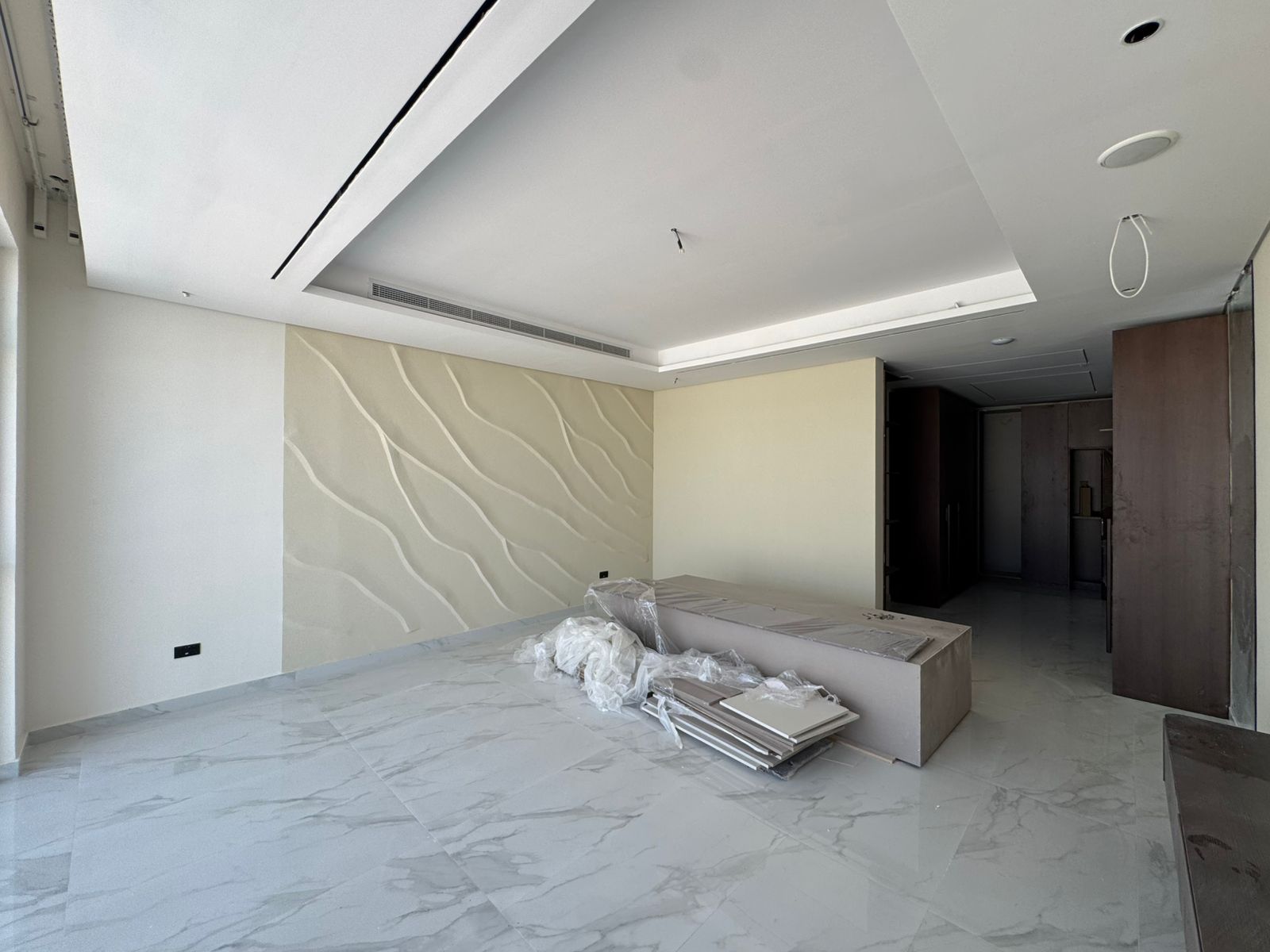 Living room with wave wall feature and marble flooring