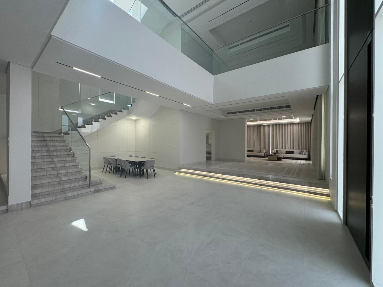 Villa double-height lobby with glass staircase and LED lighting