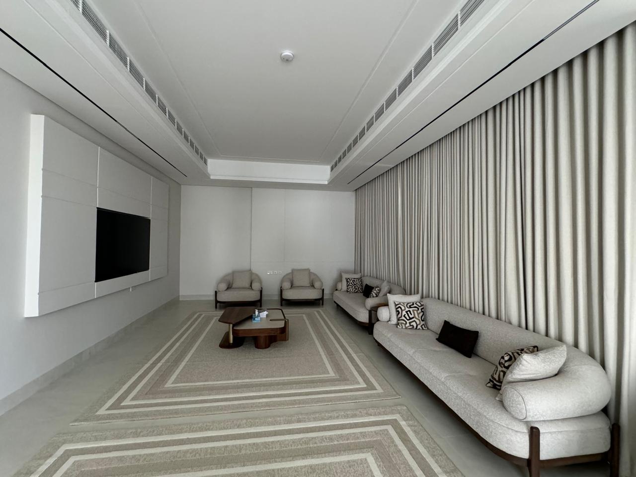 Furnished villa majlis with TV wall unit and curtains