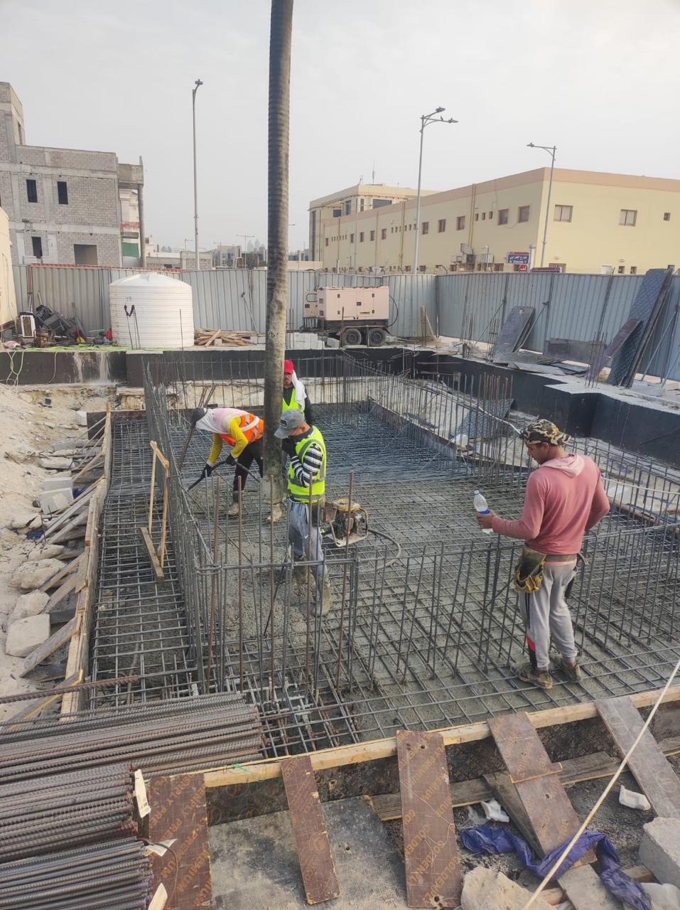 Foundation concrete pour team with vibrator on site