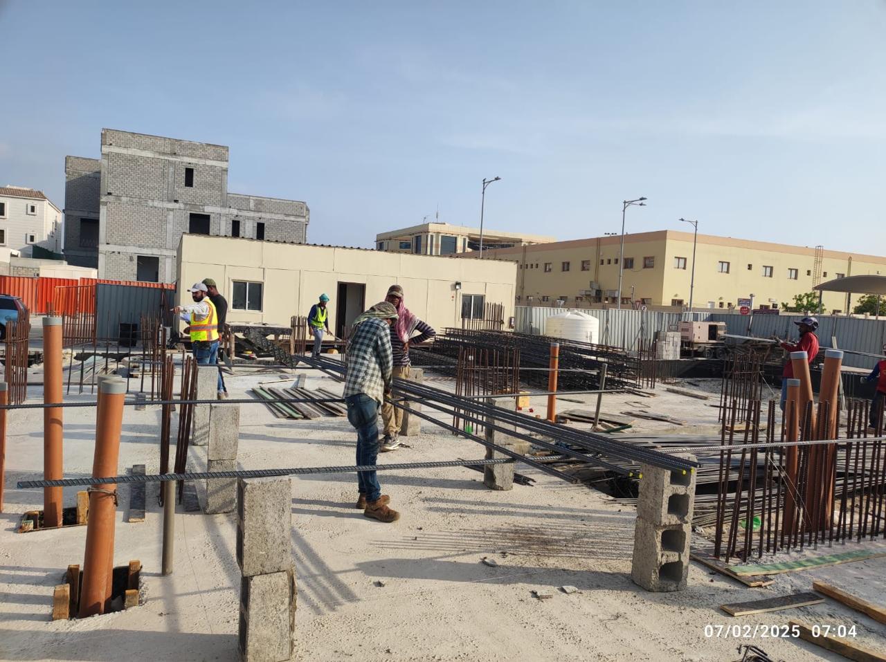 Rebar and plumbing riser installation on foundation slab