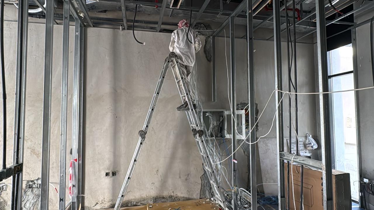 Ceiling wiring and electrical maintenance on ladder Abu Dhabi