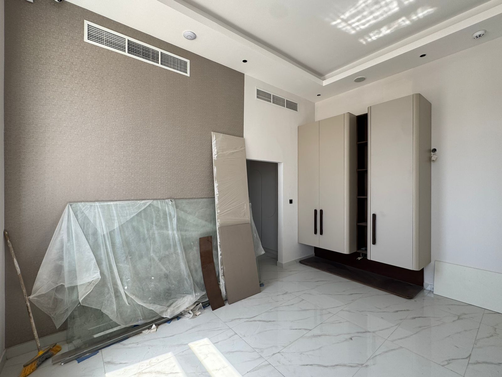 Bedroom with wallpaper accent wall and fitted wardrobe