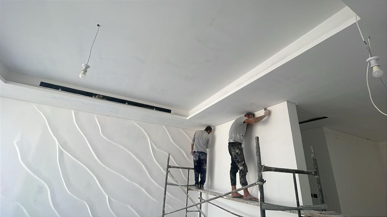 Team finishing ceiling with wave wall detail on scaffold