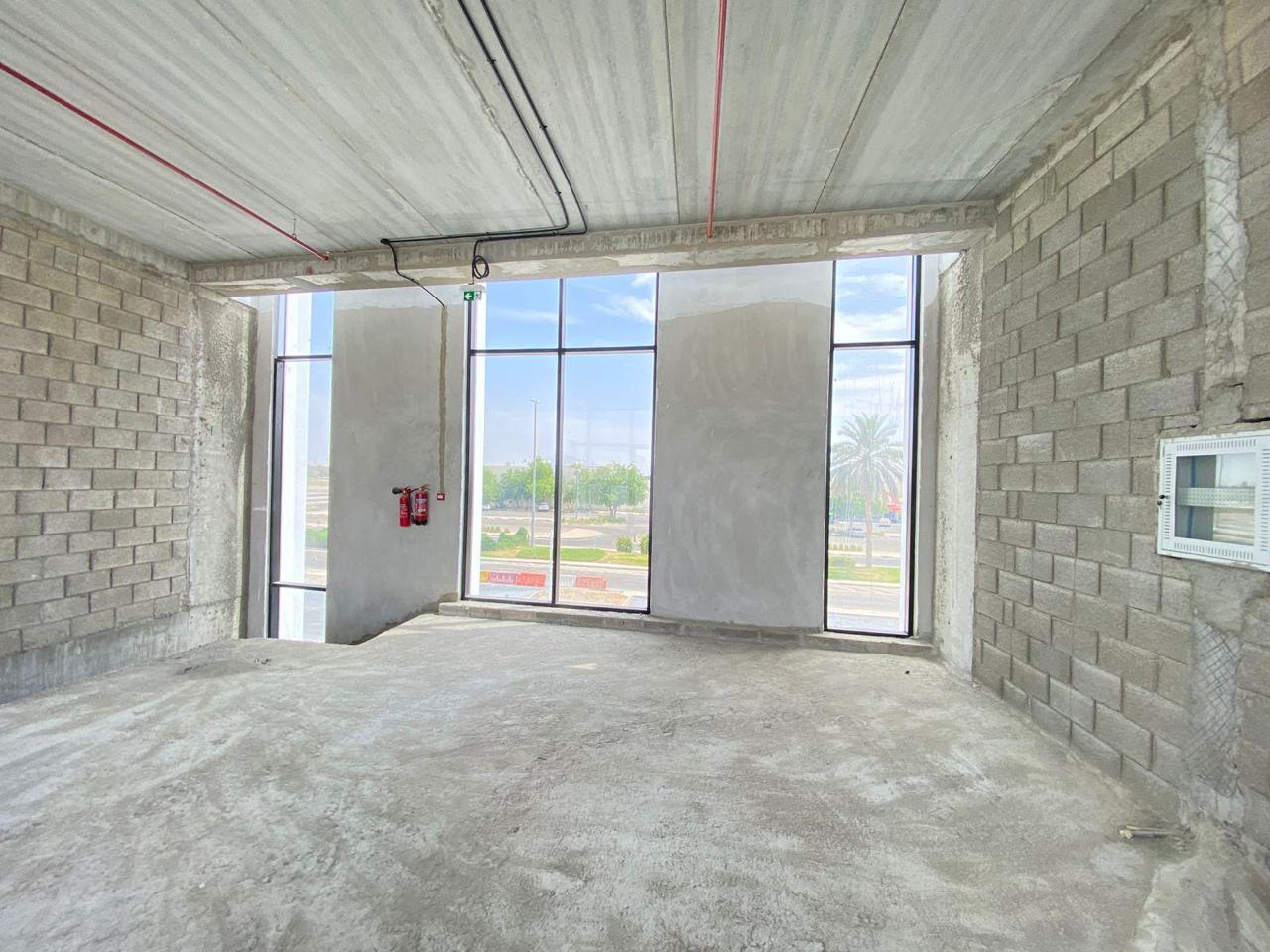 Shell corner room with glazing and fire piping overhead