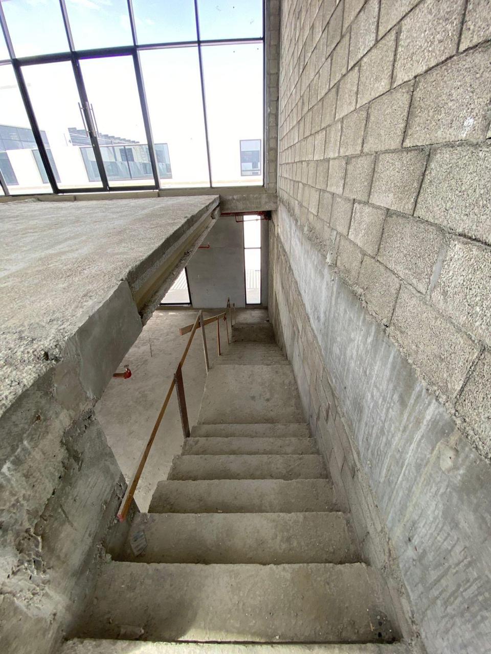 Concrete staircase looking down with temporary handrail
