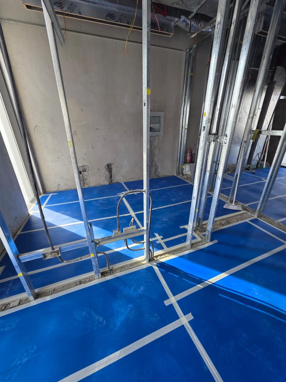 Blue waterproofing between metal stud partitions with conduit